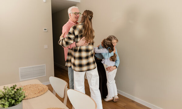 Happy family greeting and hugging during reunion at home