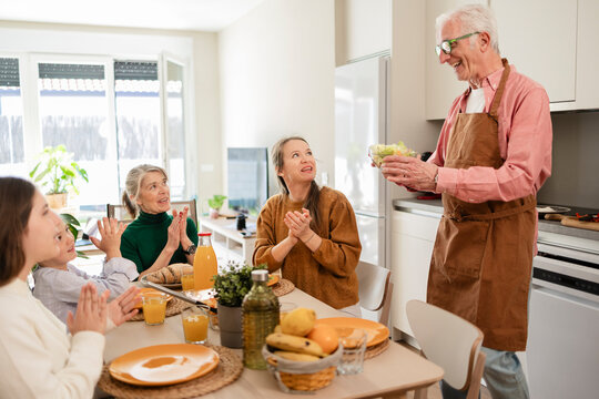 Family clapping for cook serving healthy food at indoor table