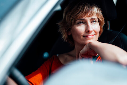 Thoughtful businesswoman with hand on chin in car