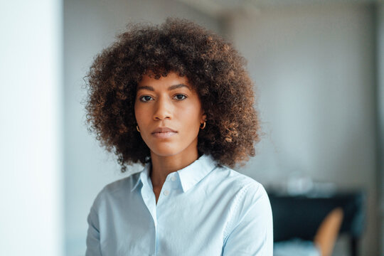 Serious businesswoman by wall at work place