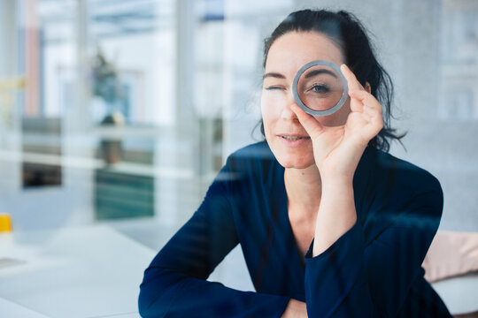 Businesswoman looking through ring shape object