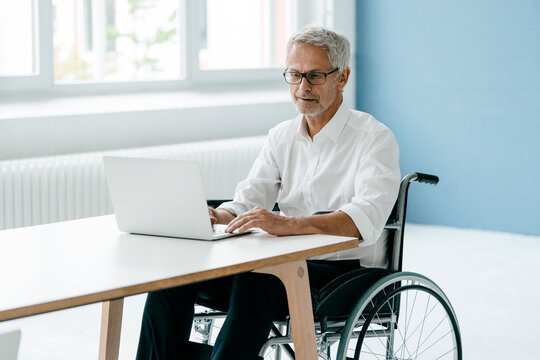 Handicapped manager in a wheelchair, working in office