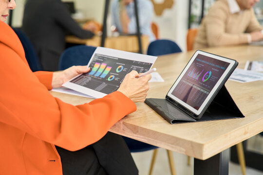 Analyst reviewing digital dashboard and chart at office desk