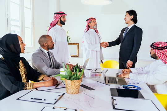 Diverse business partners shaking hands at an international meeting