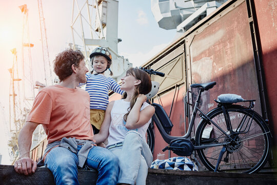 Germany, Hamburg, family having a break from a bicycle tour at the harbor