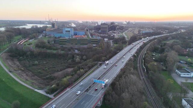 High drone view between motorway and rail at sunrise
