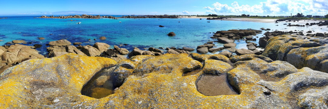 Die K&uuml;ste am Plage de Roc'h ar Gonc beeindruckt mit gelb leuchtenden Flechten auf den Granitfelsen und kleinen Gezeitent&uuml;mpeln vor dem t&uuml;rkisblauen Meer.