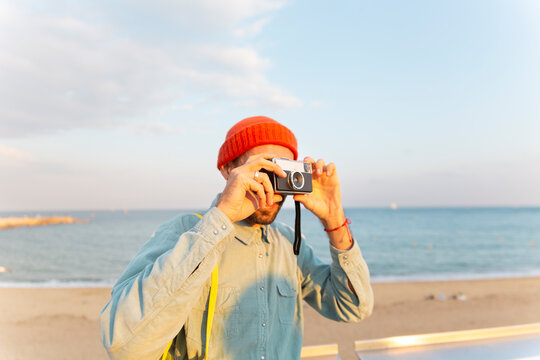 Tourist photographing with analog camera on Barcelona beach