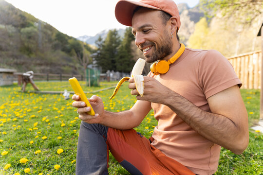 Person eating a banana and taking a selfie in a spring meadow