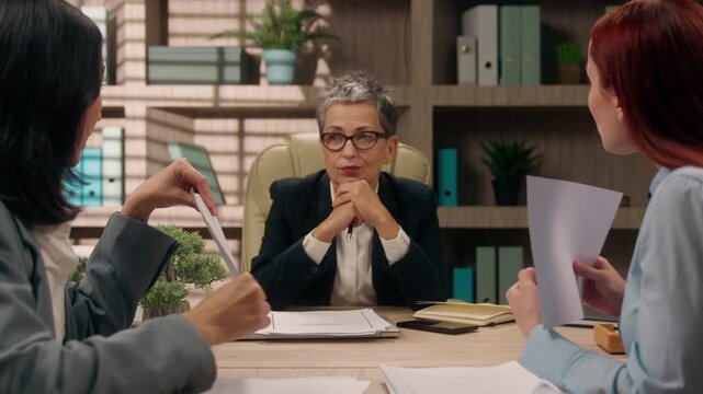 Work problem at office conference multiethnic business women arguing with documents stats showing trading line argue talk show to middle-aged boss leader team businesswomen working talking negative