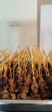 Close-up of traditional Indonesian satay skewers in a tray