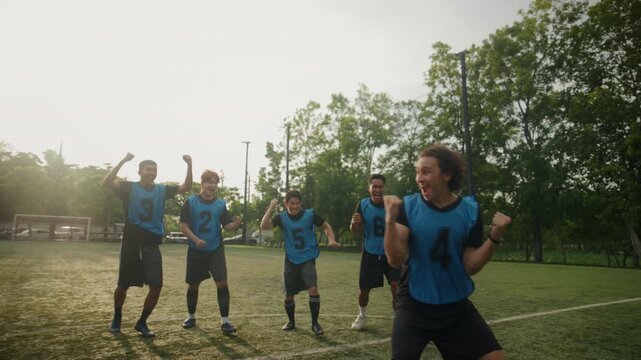Football Player Scoring Goal and Celebrating with Team on the Field