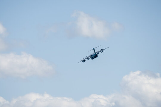 a large grey cargo plane dropping low level parachute cargo