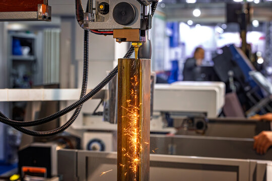 Wire EDM cutting of metal workpiece with sparks in industrial machine.