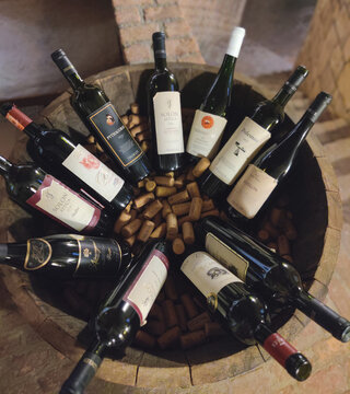 SELUK, TURKEY - JANUARY 15, 2023: Editorial shot of various bottles of 7 Bilgeler wine in a wooden barrel with corks