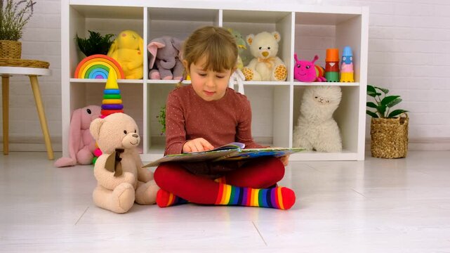 A child reads a book at home. Selective focus.