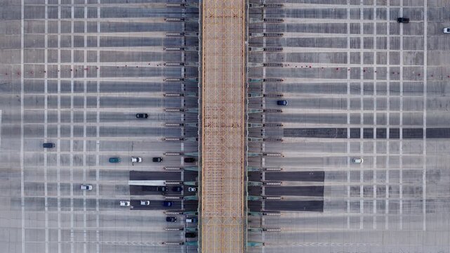 Cars Passing Through Toll Plaza Structure With Multiple Lanes. Aerial shot