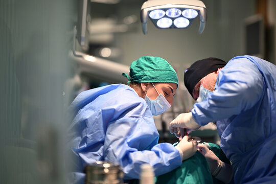 Dental Surgery Team Performing Precision Procedure in Modern Operating Room Under Surgical Light