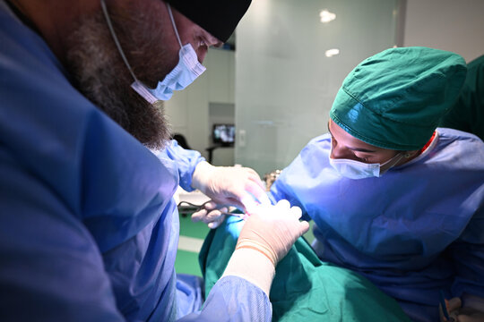 Surgeons Performing Delicate Surgery In Operating Room With Focused Teamwork And Sterile Technique