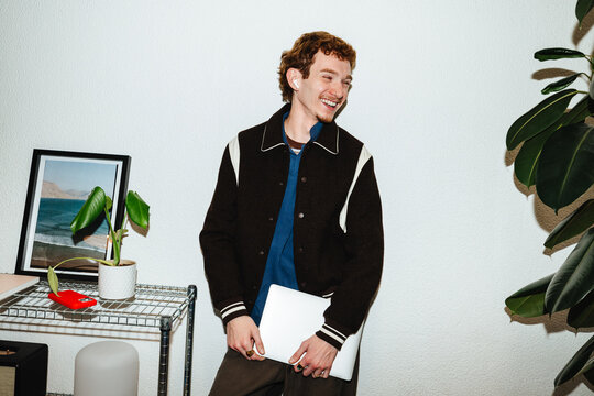 Young man with laptop at home for remote work and modern digital lifestyle