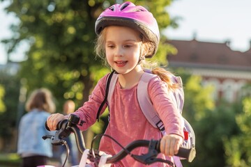 Obraz premium School Child Riding Bicycle to School With Backpack