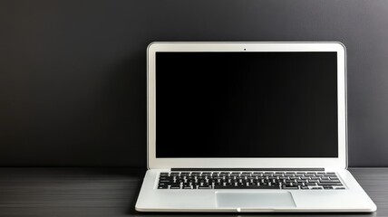 Fototapeta premium Modern silver laptop computer with blank dark screen on minimalist black wooden office desk setup.