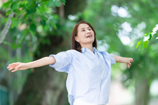 女性　深呼吸　伸び　新緑