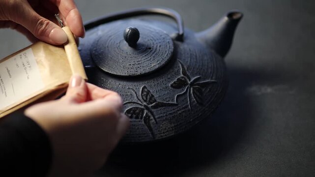 Woman Hands Opening Paper Tea Bag and Preparing Teapot for Tea Brewing, Emphasizing Calm Ritual and Traditional Home Beverage Preparation