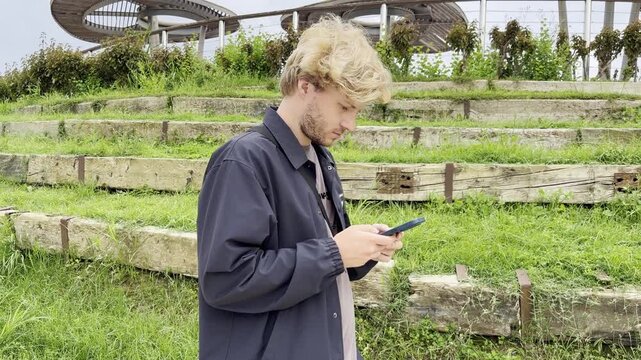 Lifestyle portrait of young man using a smartphone outdoors