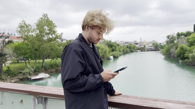 Lifestyle portrait of young man using a smartphone outdoors