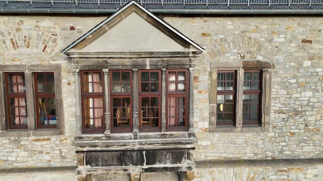 Parallel drift past ornate bay window on castle wall