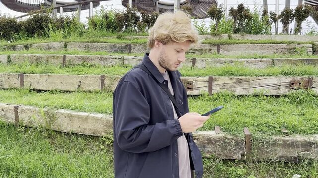 Lifestyle portrait of young man using a smartphone outdoors