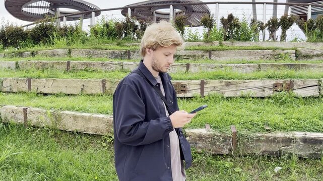 Lifestyle portrait of young man using a smartphone outdoors