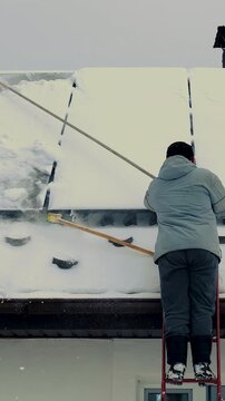 A man clears snow from solar panels. Selective focus.