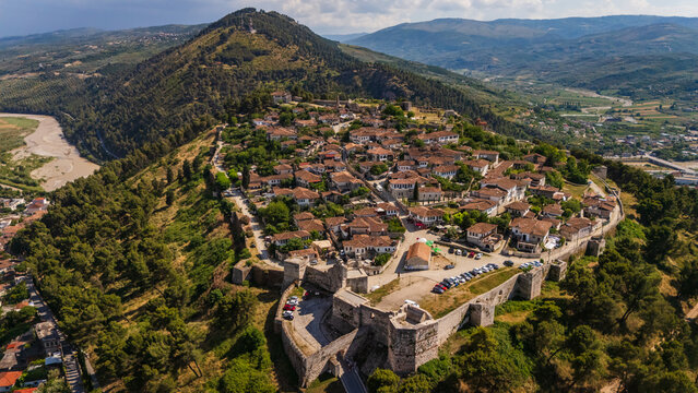 Aerial drone view of the historic Berat Castle and fortress in Albania. Panoramic cityscape of the ancient Ottoman town and stone citadel on a green hill