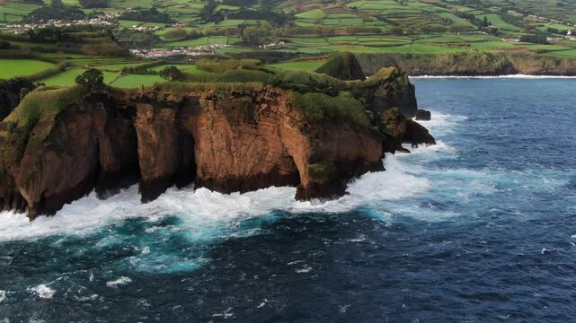 Majestic coastal cliff known as Tromba do Elefante on Sao Miguel island, Azores. Rough Atlantic Ocean waves crashing against the shoreline