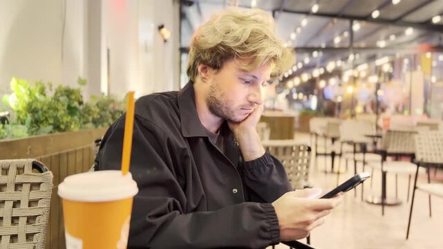 Lifestyle portrait of young man using a smartphone outdoors
