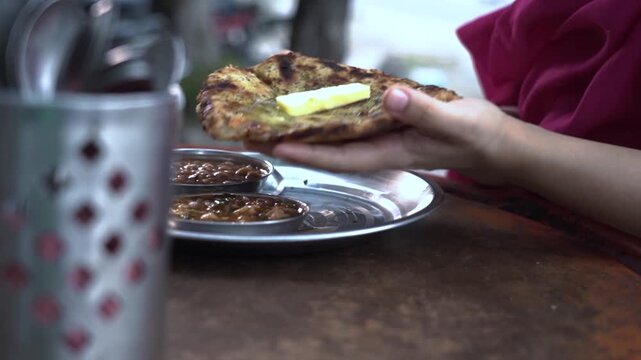 Traditional Punjabi meal featuring spicy chole, flaky laccha paratha and onion chutney.
