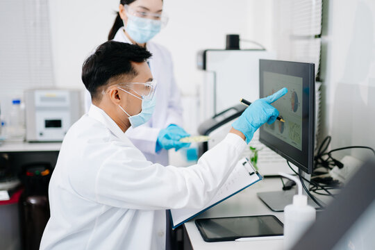 Male nutritionist in lab coat analyzing food and writing in notebook. Healthy eating, organic testing, and nutrition science