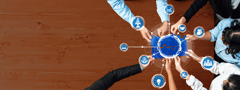 Aerial view of diverse hands connecting technology icons on a wooden table, symbolizing collaboration and innovation in business. Perfect for teamwork themes. Amity