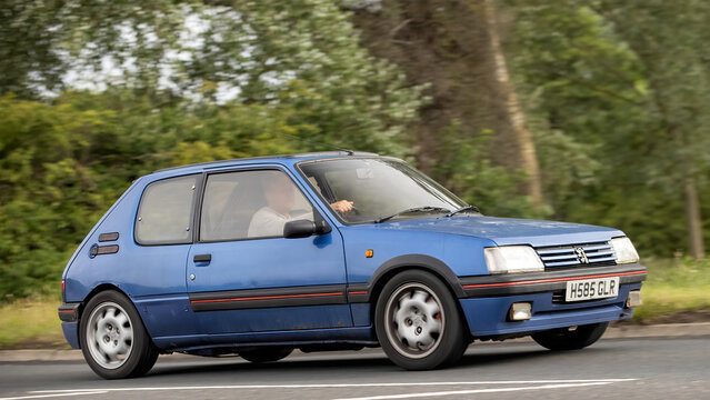 Stony Stratford,Bucks,UK - June 7th 2026: 1991 blue Peugeot 205 classic hatchback  car driving on a British road