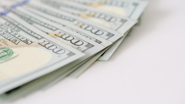 Stack hundreddollar bills beside credit chip showing layered cash edges and card EMV, freelance payout concept on white background with soft lighting and tight focus