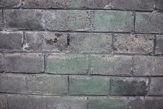Close-up of textured gray brick pavement with shallow depth of field. Ideal urban background, construction texture, stone walkway surface, and architectural design concept.