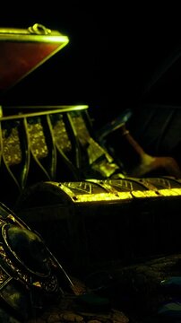 A treasure chest is open, showing gold coins and ornate items inside. The scene is dimly lit, creating shadows and highlighting the treasures details.