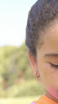 Vertical video: Framing nudging kid peeking in park, pink powder, hoop, bright collar, copy space