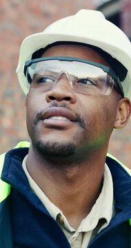 Goggles, hard hat and thinking with black man on construction site for engineering or property development. Architecture, helmet and visor with industrial worker outdoor for inspiration or planning
