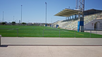 Soccer pitch with soft blurred foreground and shallow bokeh on stadium stands, outdoor  background backplate copyspace template calm. © Krakenimages.com