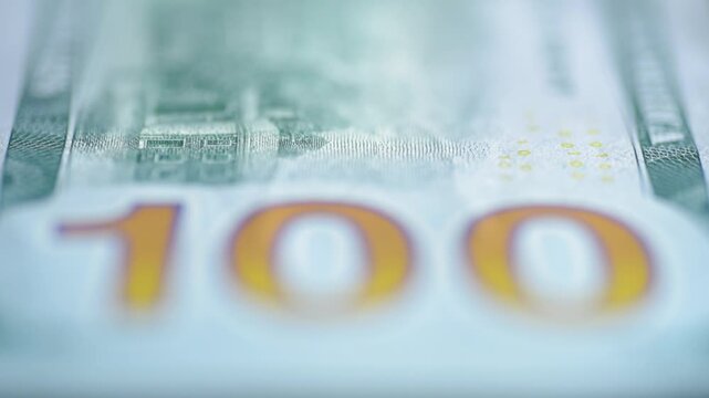 Close view emphasizing security features on banknote in forensic style. Highly detailed shot revealing intricate microprint and coloring on currency for investigative purposes