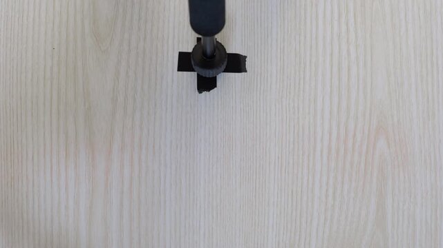 Placing tripod securely on wooden surface for consistent filming stability. Aligning and stabilizing tripod on wooden table to achieve steady video recordings throughout filming