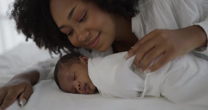 Close up portrait of beautiful young African American mother holding sleep newborn baby in hospital. Healthcare medical love black afro woman lifestyle mother's day, breast concept with copy space. 